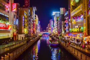 boat on river between high rise buildings during nighttime